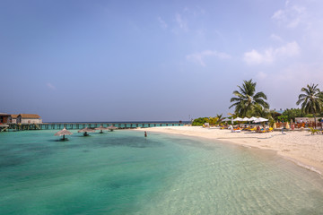 Maldives, Feb 8th 2018 - Tourists enjoying a calm beach, blue water, tropical climate, no waves in a blue sky day in Maldives.
