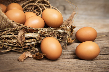 Closeup group of raw egg put on wooden timber board,vintage and art tone,blurry light around.