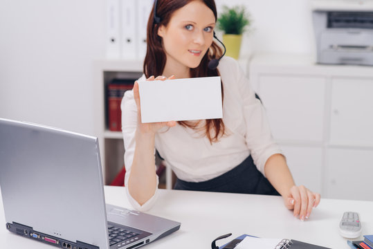attractive woman with headset working in customer suppert holding blank signboard