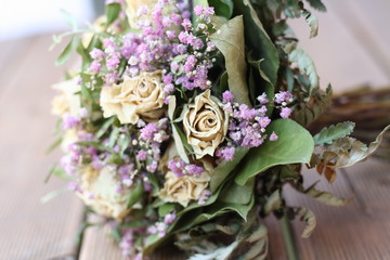 Getrockneter Blumenstrauß mit weisen Rosen und lila Blümchen