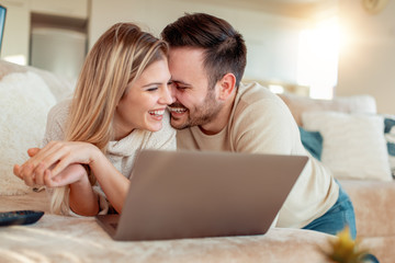 Cheerful young couple using laptop