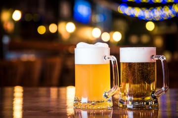Glasses of light beer on a pub background.