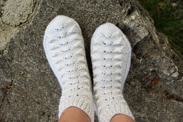 Weisse Socken mit Muster auf einem Stein