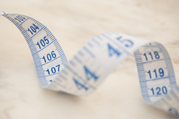 Measurring tape metter with blue figures over marbble background. Control weight, loose weight. Isoalted ribbon.