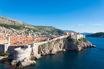 Aerial panoramic top view of old town Dubrovnik is surrounded by city walls and fortress which are located on the cliff of coastal Adriatic sea from Fort Lovrijenac in Dubrovnik, Croatia during summer