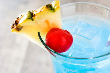 Blue Hawaiian cocktail on wooden table. Close up