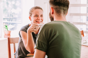 Fototapeta premium Young couple drinking coffee and having fun, flirting