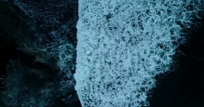 Strong waves on the evening coast with black sand. Aerial view. 4K