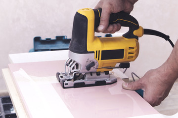 electric jigsaw in the hands of the master