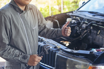 The car repairer is checking the car for maintenance. People who work on cars in the garage do their own homework. Check / inspect the engine for trouble