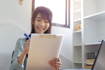 Beautiful business woman looking for documents she holds in her arms while working at her office and smile happy with her work.