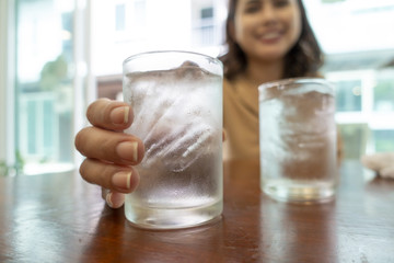Close up of hand is holding glasses of cold water