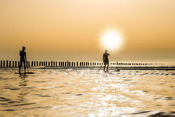jeune couple de surfeur au coucher du soleil