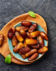 Dried dates fruits on plate. Top view of pitted dates.