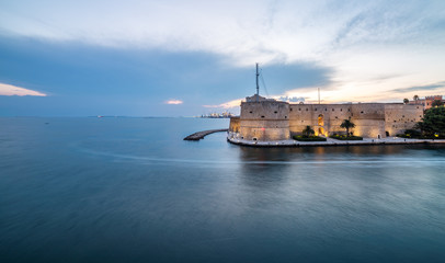 Sunset, panoramic view on Ancient Aragonese Castle in Taranto. Italy landscape on waterfront.