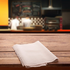 Wood table with napkin blured background cafe , for your photo montage or product display. Space for placing items on the table.