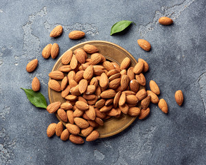 Almond nuts on gray concrete background with copy space. Top view.