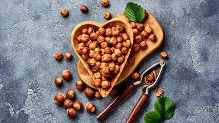 Hazelnuts with nutcracker on gray background. Top view of nuts.