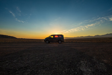 Obraz na płótnie Canvas SUV in the field at sunset