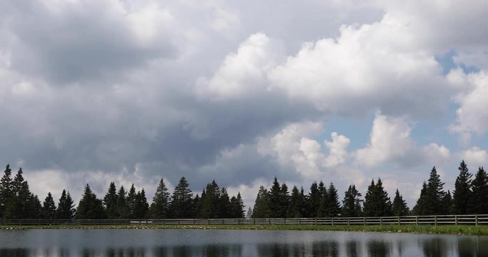 Beautiful cloudy day over lake with trees. Rogla, Slovenia.