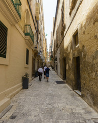 Fototapeta na wymiar People Walking Narrow Maltese Street