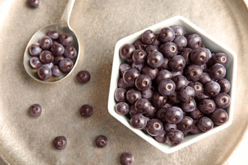Bowl with fresh acai berries on tray, top view