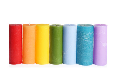 Different colorful wax candles on white background