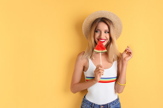 Pretty young woman with juicy watermelon on color background