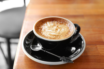 Cup of fresh aromatic coffee on table