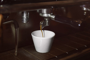 Preparing fresh aromatic coffee on modern machine, closeup