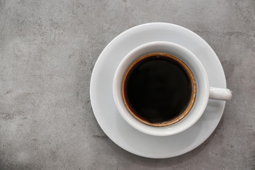 Cup of fresh aromatic coffee on grey background, top view