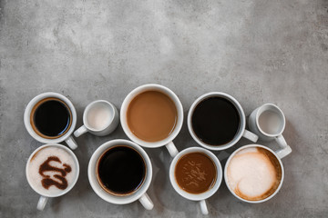 Obraz na płótnie Canvas Cups of fresh aromatic coffee on grey background, top view