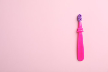 Manual toothbrush for child on color background, top view with space for text