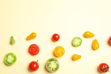 Flat lay composition with different tasty tomatoes and space for text on color background