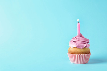 Delicious birthday cupcake with candle and space for text on color background