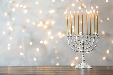 Hanukkah menorah with candles on table against blurred lights - obrazy, fototapety, plakaty