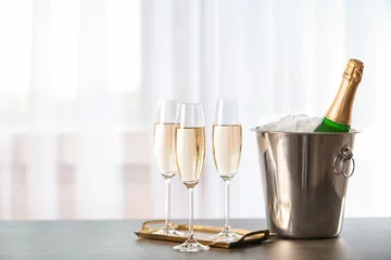 Deurstickers Glazen met champagne en fles in emmer op tafel © New Africa