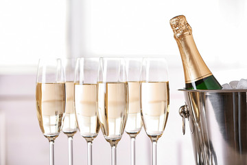 Glasses with champagne and bottle in bucket against blurred background © New Africa