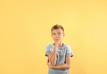 Adorable little boy in casual clothes on color background