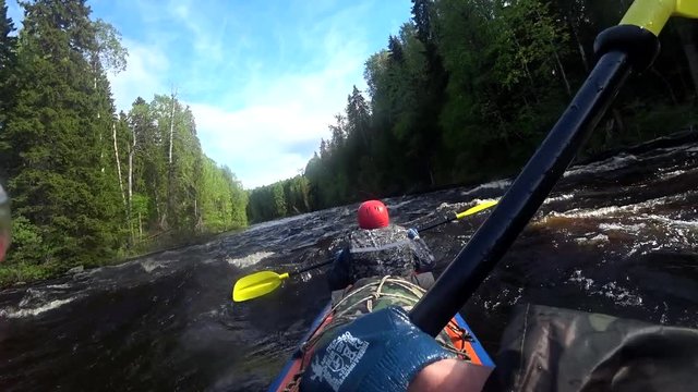 River rafting kayaking. Overcoming water rapids by boat. Rowing paired paddle. Extreme sports. Water sports. Shooting Action camera.