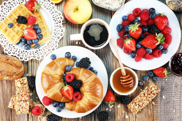 breakfast on table with waffles, croissants, coffe and juice.