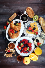 breakfast on table with waffles, croissants, coffe and juice.