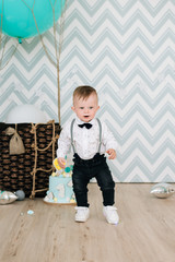Naklejka premium Baby's first birthday. Cute smiling baby is 1 year old. The concept of a children's party with balloons