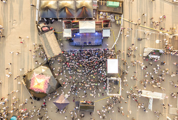 aerial top view of crowd of people standing near the stage on concert on summer day