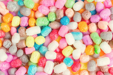 Multicolored corn balls lie on the table. Background. A game for children. Manipulation