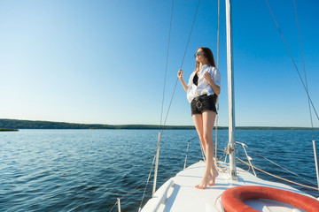 Girl standing on the bow of a sailboat, boat. Copy space