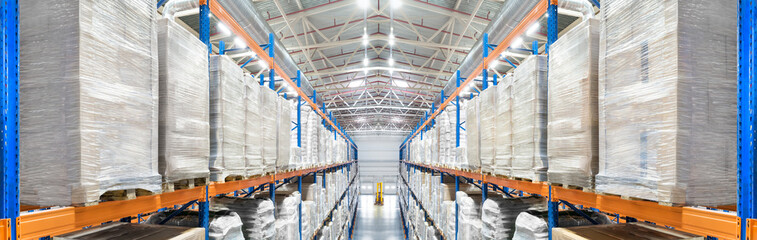 Panorama of a modern newest huge distribution warehouse with high shelves and big ventilation pipes on the ceiling. Top view