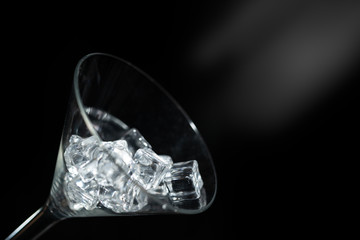 Close up view champagne glass of ice in black background with flare.