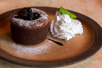 lava cake and cream aside on a brown plate gourmet concept photo