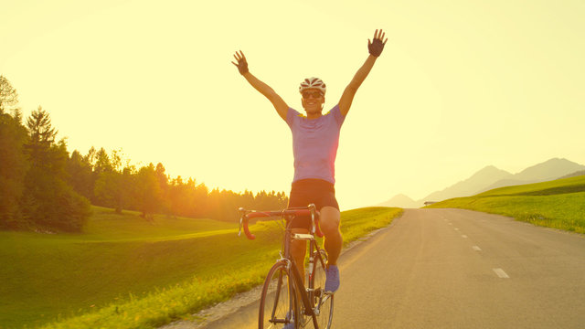 SUN FLARE: Pro Cyclist Cheerfully Rides Road Bike With No Hands After Victory.